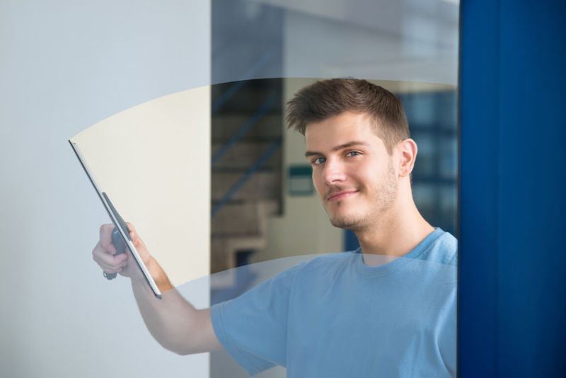 45610024 - young male worker cleaning glass with squeegee