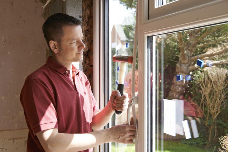 45009140 - construction worker installing new windows in house