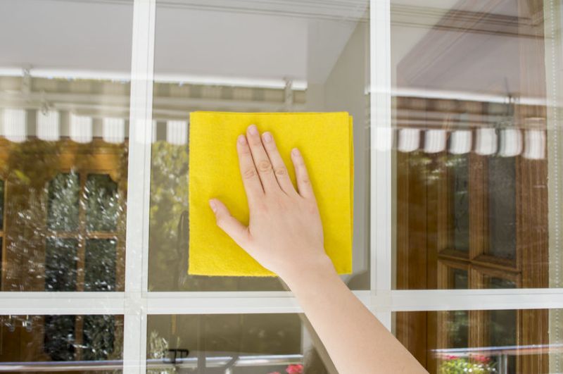 24365034 - woman cleaning glass outdoor with a yellow cloth